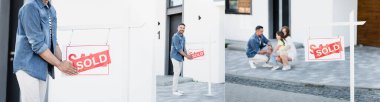 Ailenin çömelme kolajı, kameraya bakan ve tabela tutan bir adam. Evin yanında satılan harfler, afişler.