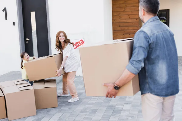 Gelukkig Vrouw Meisje Holding Pakket Terwijl Kijken Naar Wazig Man — Stockfoto