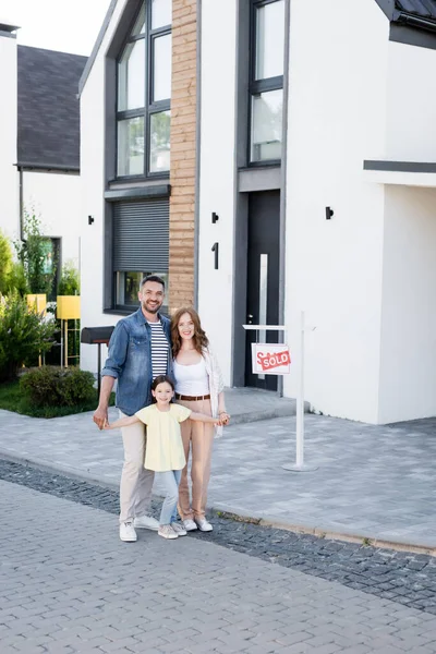 Happy Family Hugging Looking Camera While Standing House Sign Sold — Stock Photo, Image