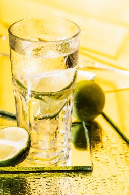 Sarı limonun yanında bir bardak alkol kokteyli. 