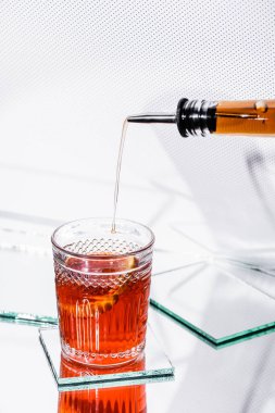 Viski bardağa dökülüyor. Kokteyl şişeden, şeker kutusuna da beyaz şarap.