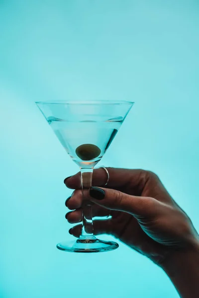Vista Recortada Mujer Sosteniendo Vaso Martini Con Olivo Aislado Azul — Foto de Stock