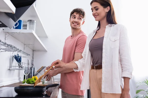 Lächelnder Mann Schaut Freundin Beim Kochen Auf Herd Küche — Stockfoto