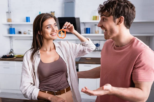 Mujer Sonriente Sosteniendo Rebanada Pimentón Cerca Novio Cocina — Foto de Stock