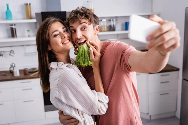 Cheerful Couple Lettuce Taking Selfie Smartphone Blurred Foreground — Stock Photo, Image