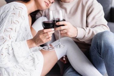 Kırpılmış şarap kadehleri, bulanık arka planda genç bir coupe 'nin ellerinde. 