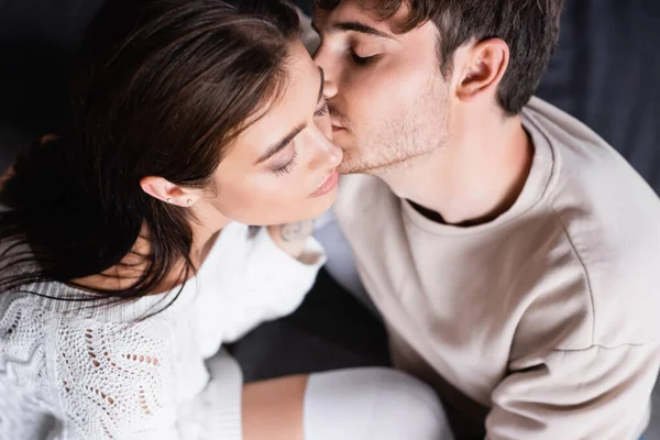 Overhead view of man kissing girlfriend at home