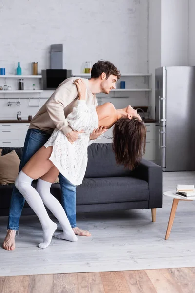 Barefoot Man Embracing Brunette Girlfriend Knee Socks Home — Stock Photo, Image