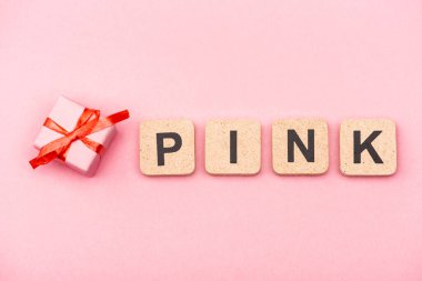 Küpler ve hediye kutusunda pembe kelimenin üst görünümü