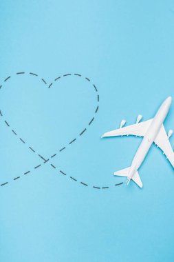 top view of white plane model and heart on blue background clipart