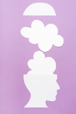 top view of paper human head and clouds on violet background clipart