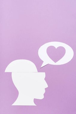 top view of paper human head and speech bubble with heart on violet background clipart
