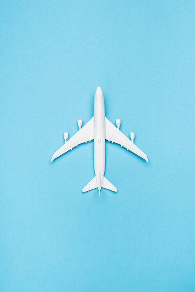 top view of white plane model on blue background