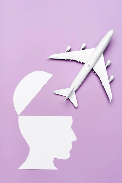 비행기 모형과 종이가 보라색 배경에 사람의 머리를 — 스톡 사진