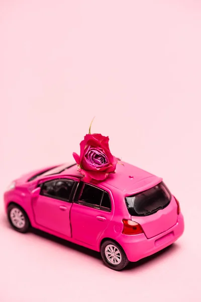 Παιχνίδι Αυτοκίνητο Και Κόκκινο Τριαντάφυλλο Ροζ Φόντο — Φωτογραφία Αρχείου