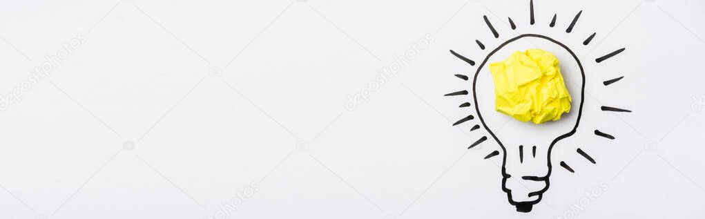 top view of light bulb with crumpled paper on white background, banner