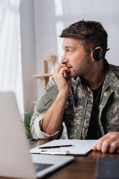 Orolig Militär Man Uniform Och Headset Tittar Bort Nära Laptop — Stockfoto