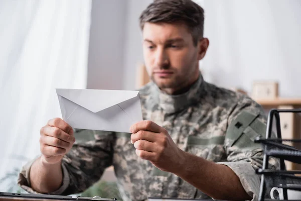 Vit Kuvert Händerna Soldat Suddig Bakgrund — Stockfoto