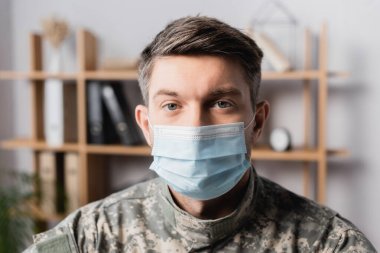 military man in uniform and medical mask looking at camera clipart