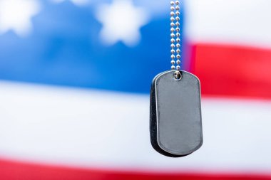 Bulanık arkaplanda Amerikan bayrağı yakınındaki boş metalik rozeti kapat