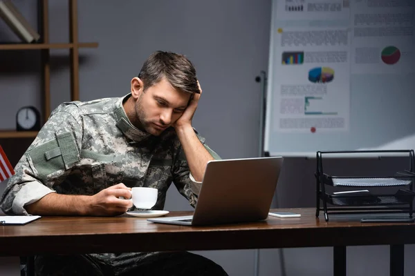 Trött Militär Man Uniform Hålla Kopp Och Använda Laptop Kvällen — Stockfoto