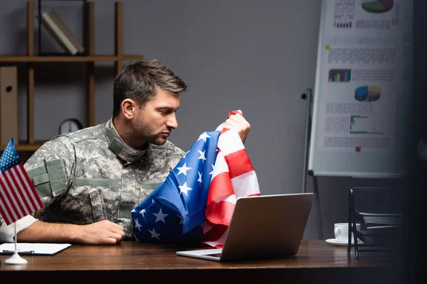 Ledsen Militär Man Uniform Innehav Flagga Amerika Nära Laptop — Stockfoto