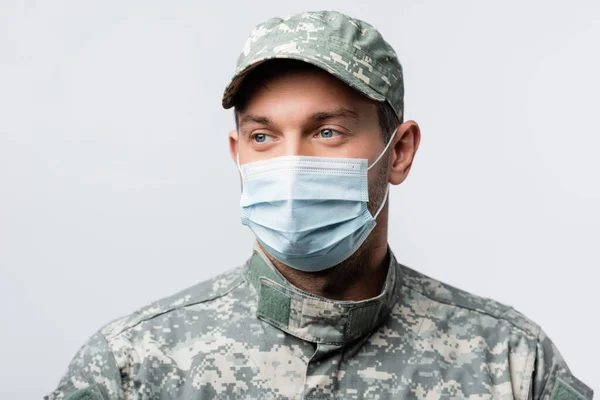 military man in uniform and medical mask looking away isolated on white
