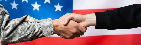 Krysset Syn Soldat Som Håndhilste Sivil Mann Nær Amerikansk Flagg – stockfoto