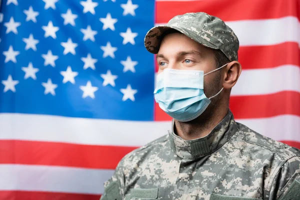 Wojskowy Masce Medycznej Pobliżu Amerykańskiej Flagi Zamazanym Tle — Zdjęcie stockowe