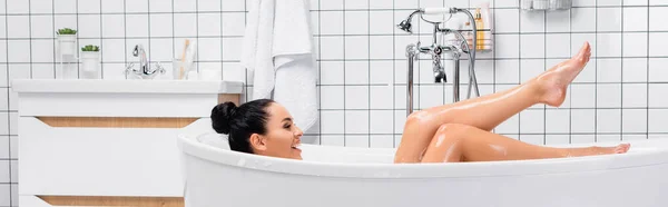 Mujer Sonriente Mirando Las Piernas Mojadas Mientras Toma Baño Pancarta — Foto de Stock