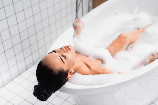 Mujer Morena Relajándose Baño Con Espuma Sobre Fondo Borroso — Foto de Stock