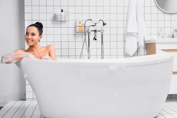 Mulher Morena Positiva Olhando Para Longe Enquanto Sentada Banheira Com — Fotografia de Stock