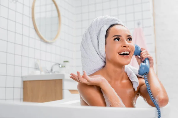 Mujer Alegre Espuma Toalla Cabeza Hablando Por Teléfono Bañera Primer —  Fotos de Stock