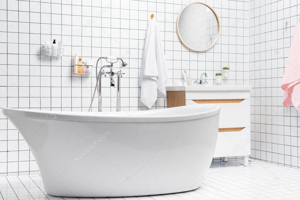 Interior of white bathroom with bathtub and toiletries 