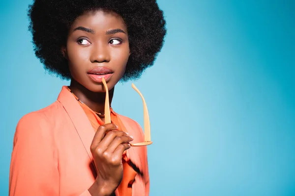 Αφροαμερικανή Νεαρή Γυναίκα Πορτοκαλί Στυλάτο Ντύσιμο Απομονωμένη Μπλε Φόντο — Φωτογραφία Αρχείου
