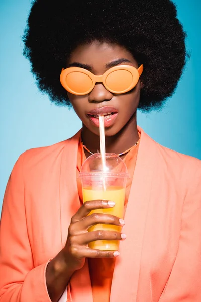 Αφροαμερικανή Νεαρή Γυναίκα Κομψό Ντύσιμο Χυμό Πορτοκάλι Απομονωμένη Μπλε Φόντο — Φωτογραφία Αρχείου