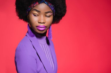 Kırmızı üniformalı Afro-Amerikan genç bir kadın.
