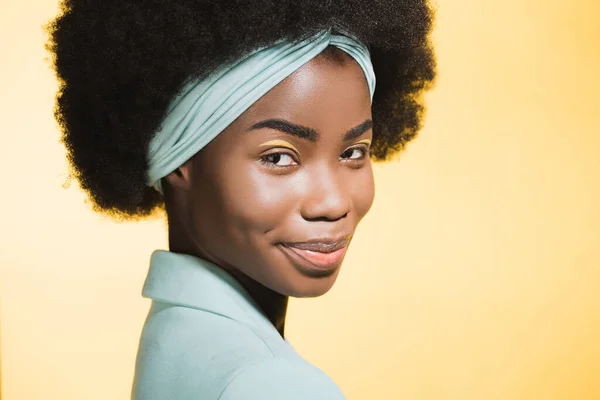 笑着的非洲裔美国年轻女子 身穿蓝色时髦服装 与黄色隔离 — 图库照片