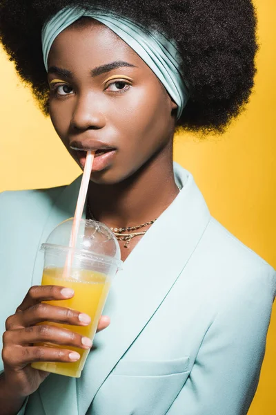 Afrykańska Młoda Kobieta Niebieskim Stylowym Stroju Sokiem Pomarańczowym Odizolowanym Żółto — Zdjęcie stockowe