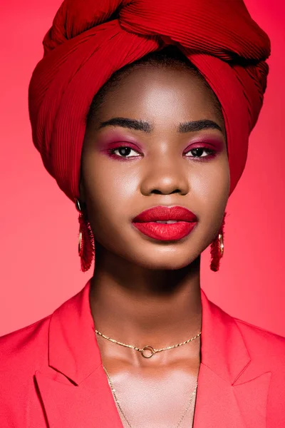 stock image african american young woman in stylish outfit and turban isolated on red