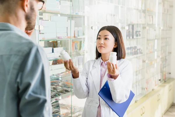 Farmacéutico Asiático Blanco Abrigo Celebración Portapapeles Botellas Con Medicamentos Cerca — Foto de Stock