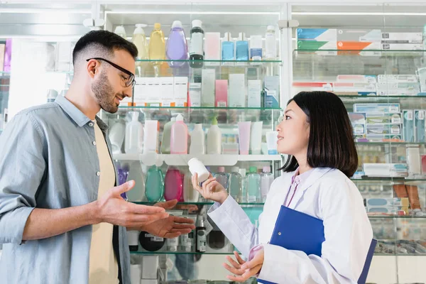 Vista Lateral Alegre Asiático Farmacéutico Blanco Abrigo Celebración Portapapeles Botella — Foto de Stock