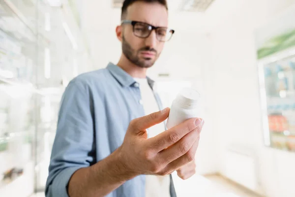 Frasco Con Medicamentos Mano Del Hombre Gafas Sobre Fondo Borroso —  Fotos de Stock