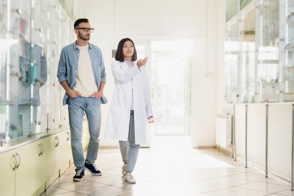 Longitud Completa Asiático Farmacéutico Blanco Capa Apuntando Con Mano Mientras — Foto de Stock