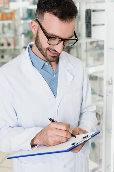 Vidám Gyógyszerész Szemüvegben Írótáblára Írva Gyógyszertárban — Stock Fotó