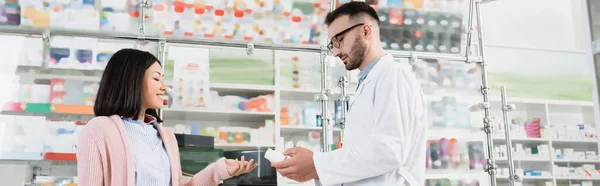 Farmacêutico Barbudo Óculos Casaco Branco Dando Garrafa Com Pílulas Para — Fotografia de Stock