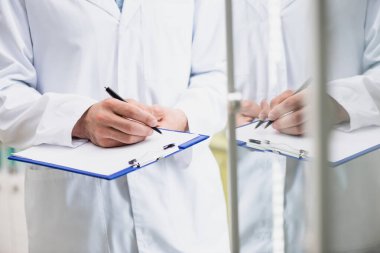 Panoya yazarken elinde kalem tutan eczacının kırpılmış görüntüsü 