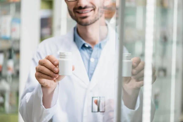 Vista Recortada Feliz Farmacéutico Sosteniendo Botella Con Pastillas Cerca Vidrio — Foto de Stock