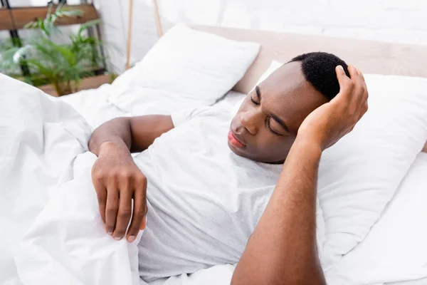 Afroamericano Uomo Toccare Testa Mentre Sdraiato Letto — Foto Stock