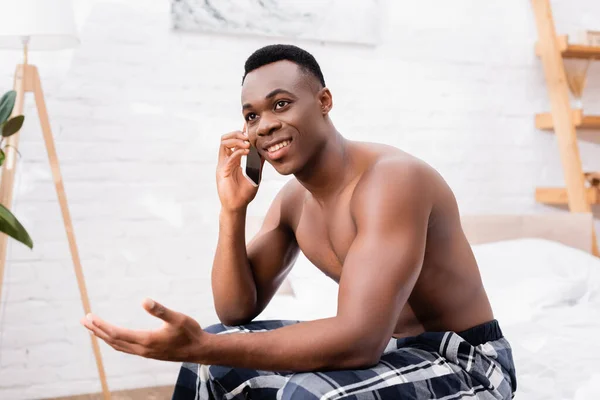 Félmeztelen Afro Amerikai Férfi Mosolyog Miközben Beszél Okostelefonon Hálószobában — Stock Fotó